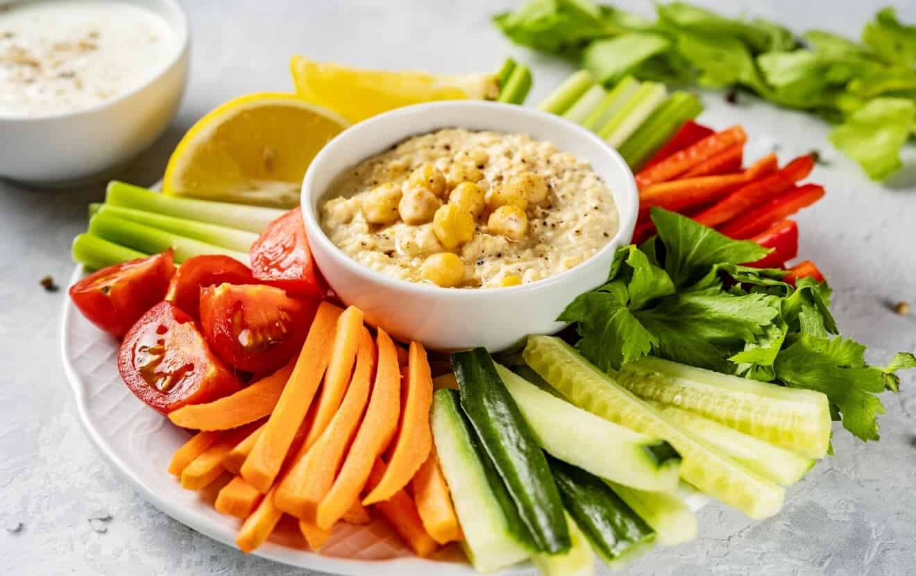Gesund grillen: Gemüseplatte mit Gurke, Karotte, Tomate, Paprika und dazu Hummus