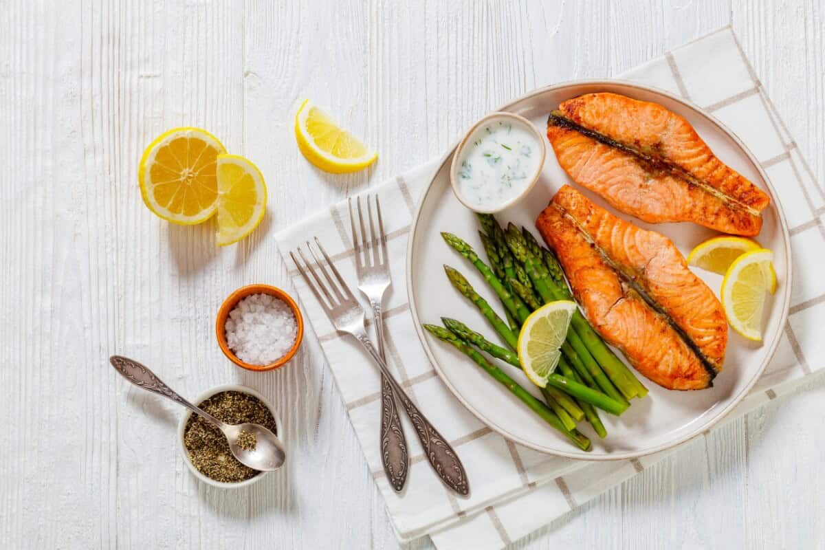 Leichte Abendmahlzeit mit wenig Kohlenhydraten und viel Protein: Lachs mit frischem grünem Spargel, Joghurt-Dip und Zitrone.